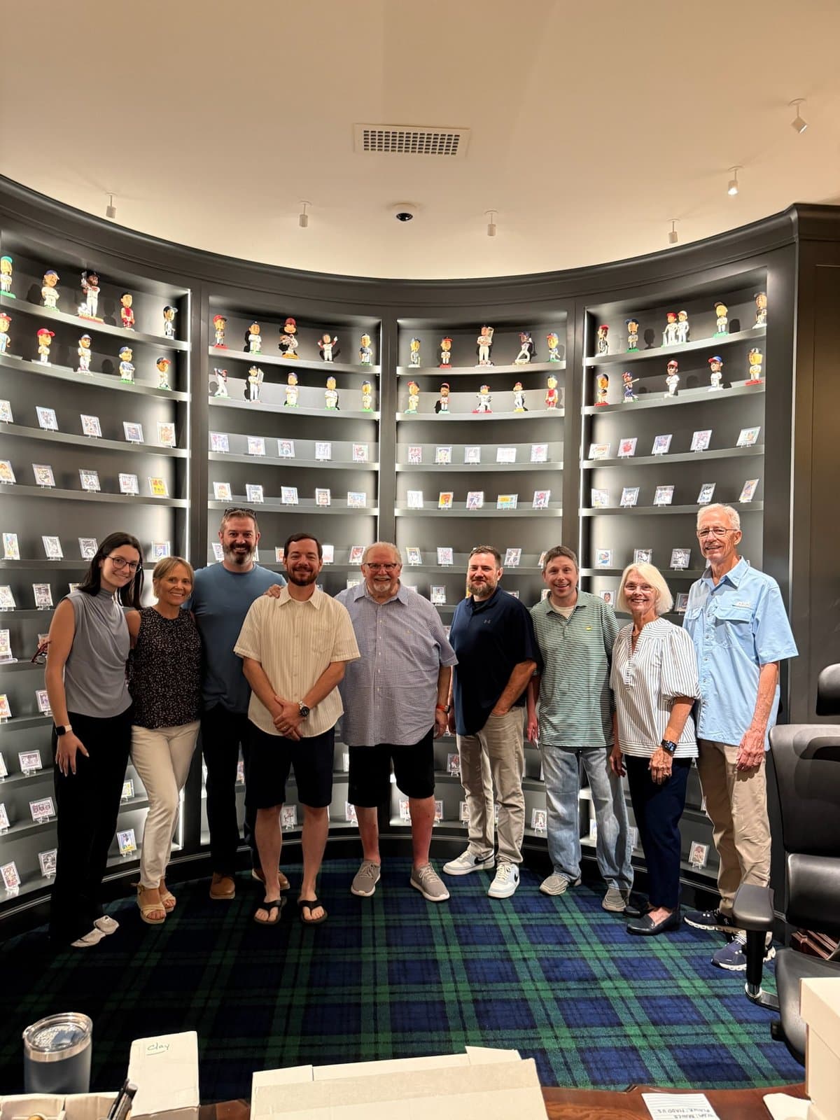 The CardFather and a group of visitors in front of the curved wall of cards.