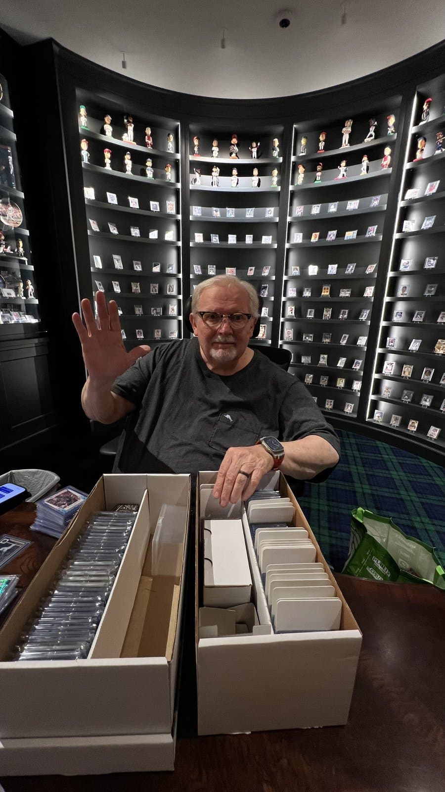 The CardFather waving from his sorting table, boxes of cards open in front of him.